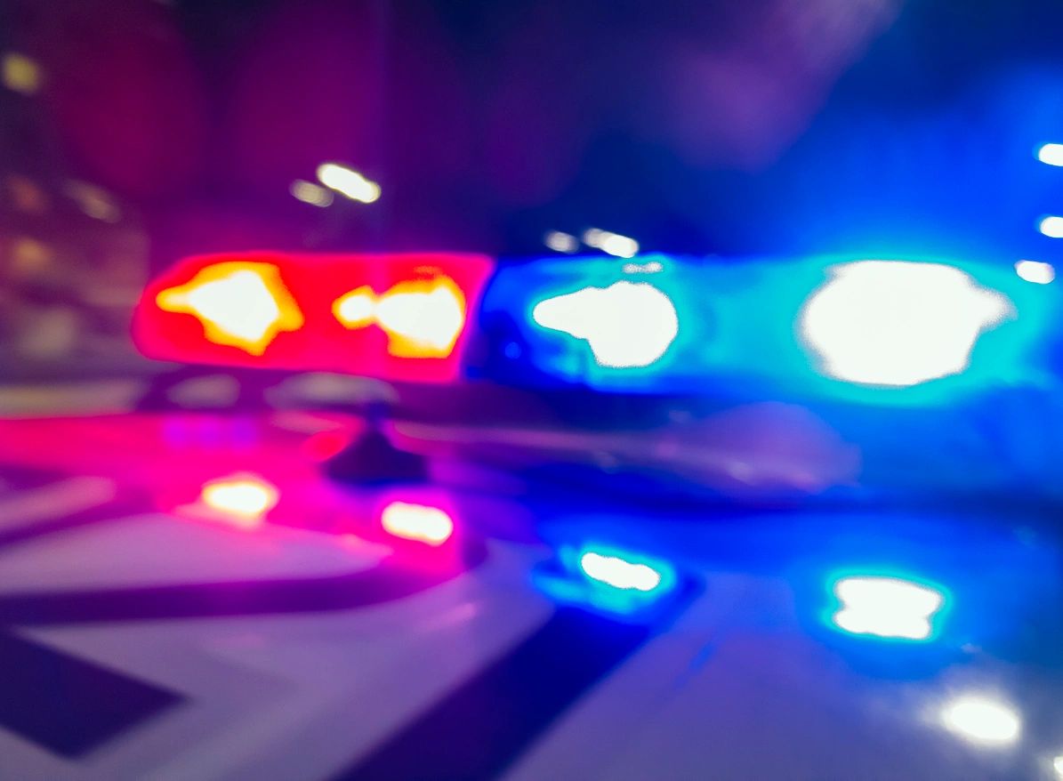 Flashing police lights illuminating a scene at night.